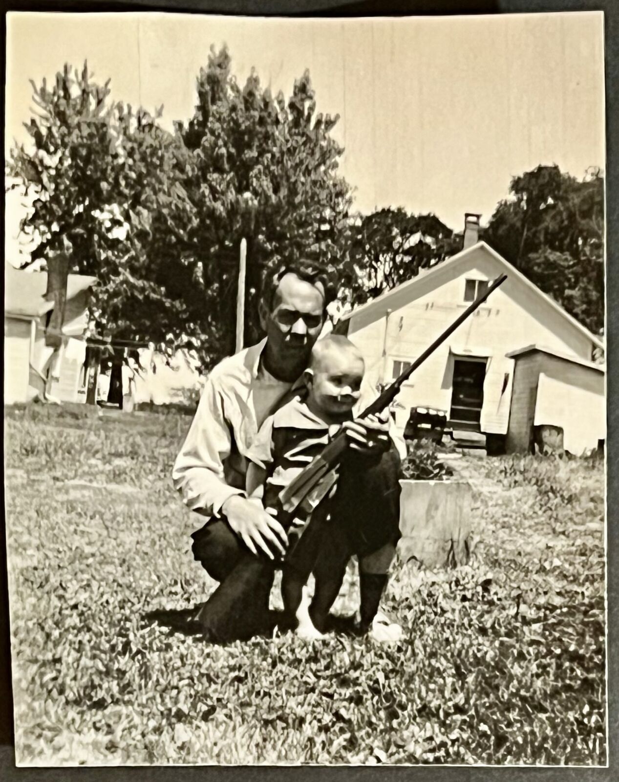 Snapshot of kneeling father & infant son holding a shotgun Ferrisburgh Vermont